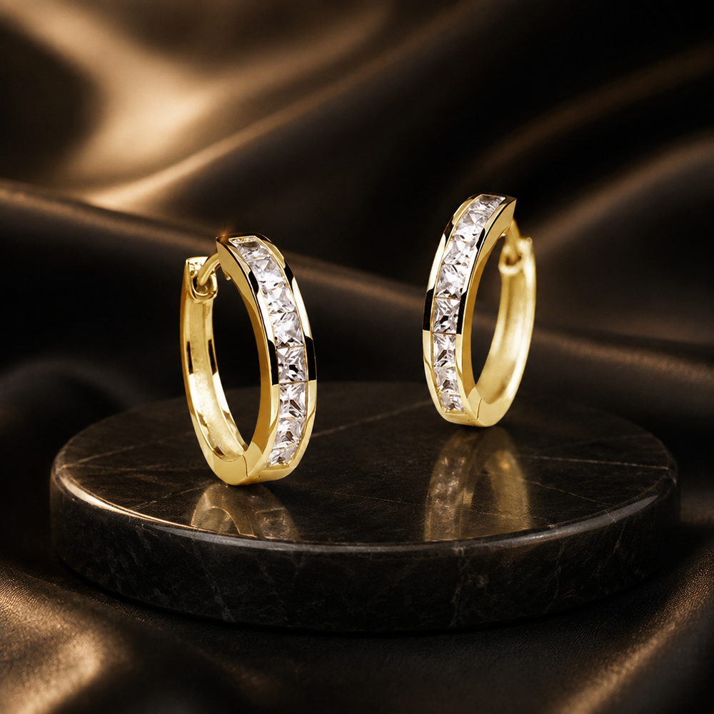 Éclat gold zircon hoop earrings on black satin
