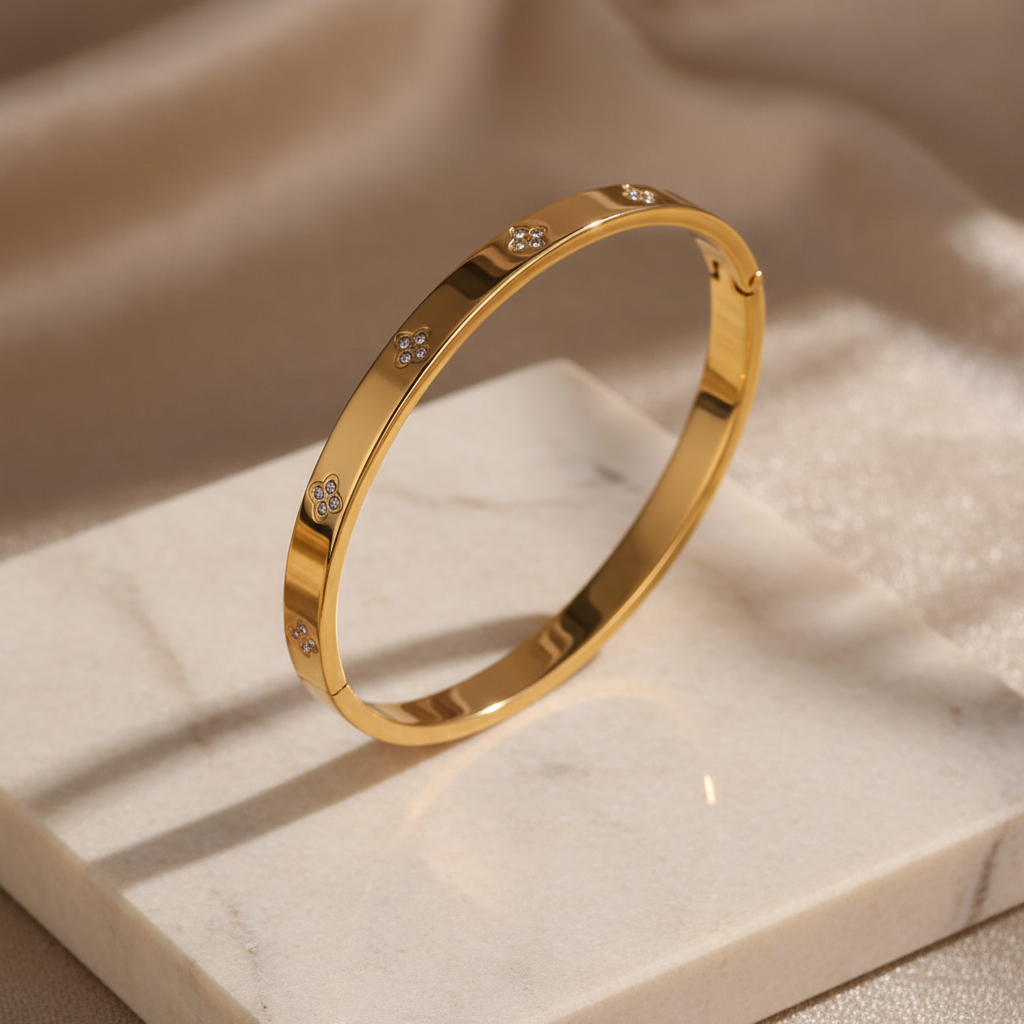 Signature gold clover zircon bangle on ivory stone — detail 1
