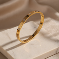 Signature gold clover zircon bangle on ivory stone — detail 1