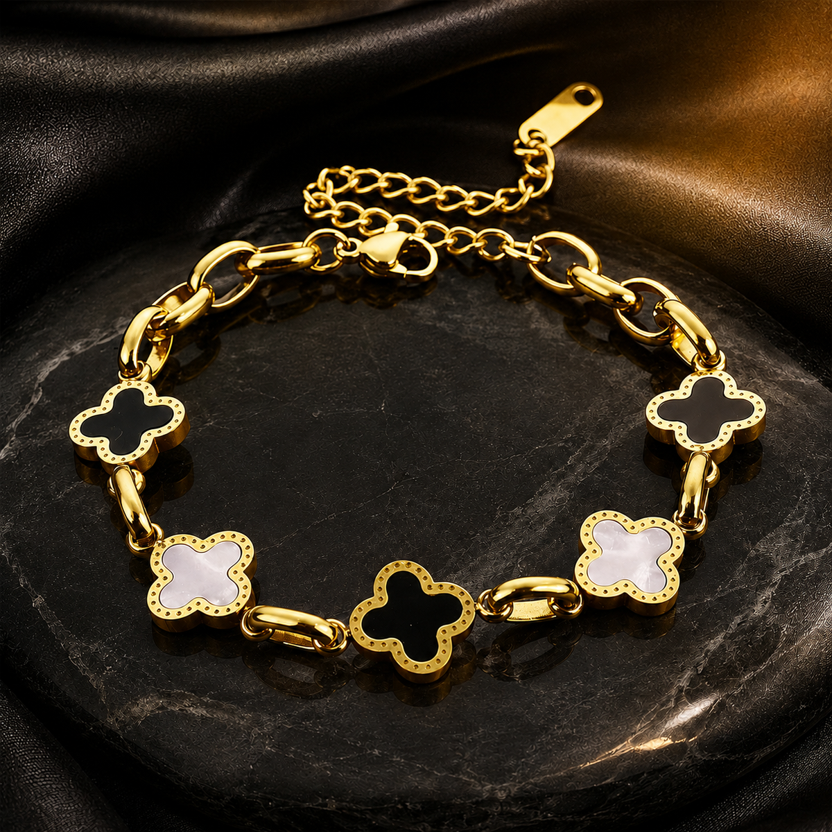Élan Trèfle four-leaf clover charm bracelet on a black-and-gold background
