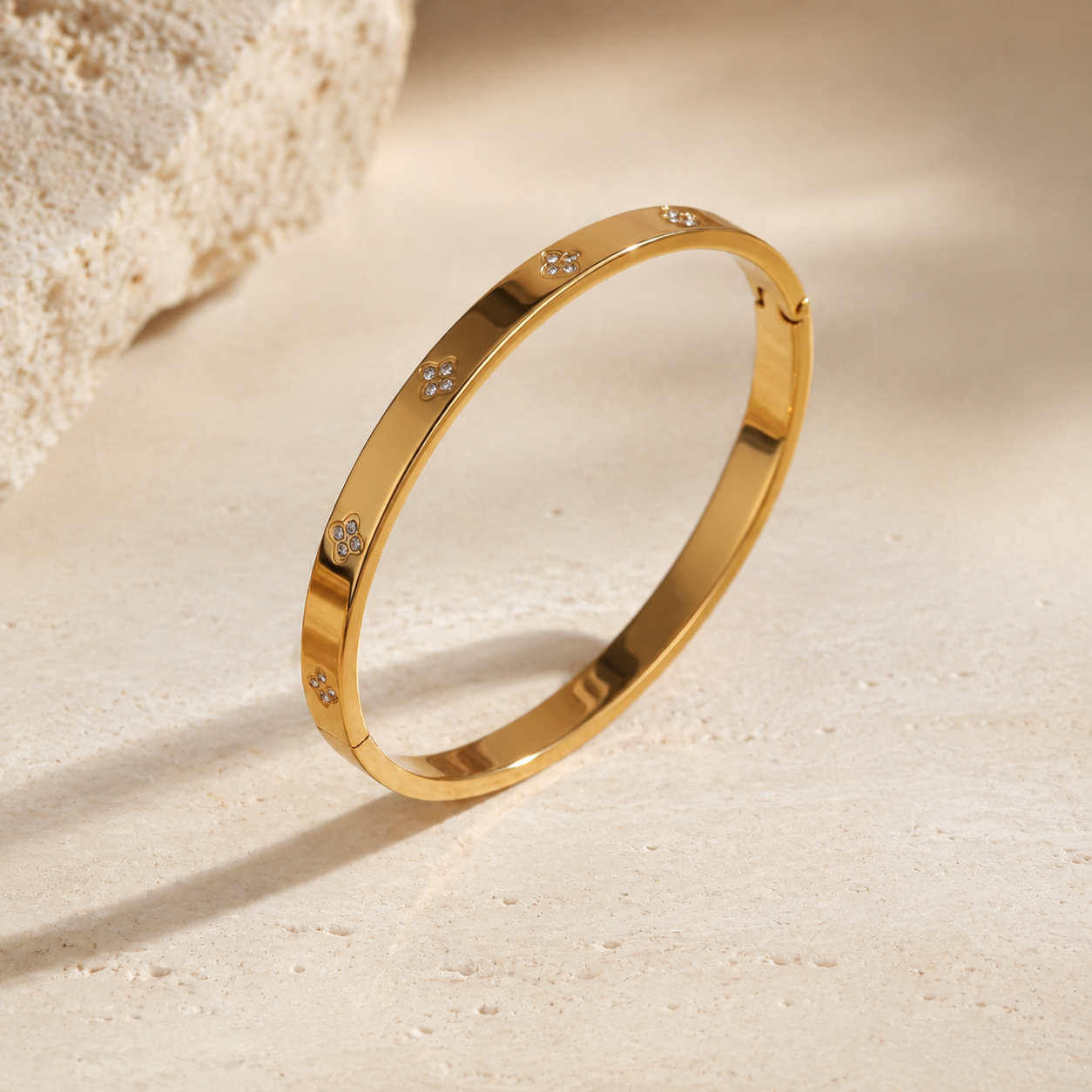 Signature gold clover zircon bangle on ivory stone
